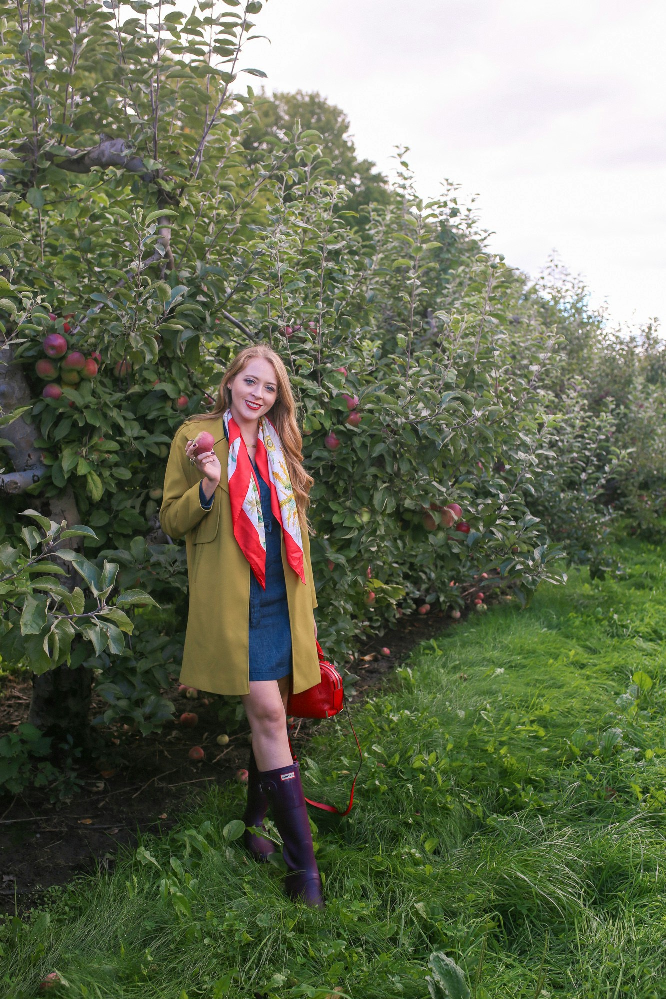 Apple picking outfit idea: green trench, vintage Gucci scarf, denim dress and Hunter boots