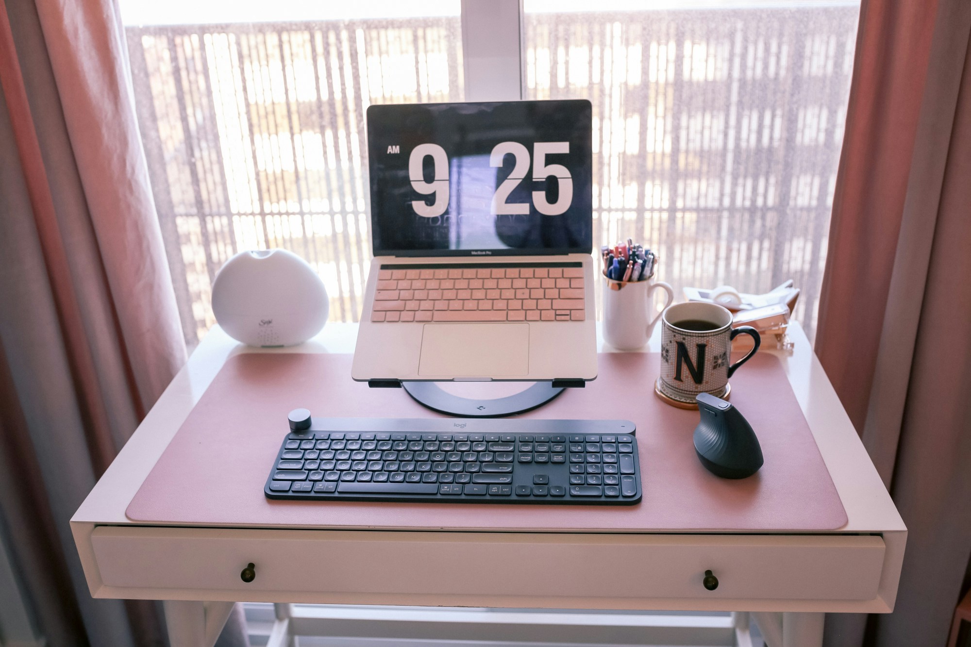 What's on my desk? An ergonomic laptop stand, logitech keyboard and mouse and a Saje essential oil diffuser keep me comfortable and focused while I work from home during self-isolation.
